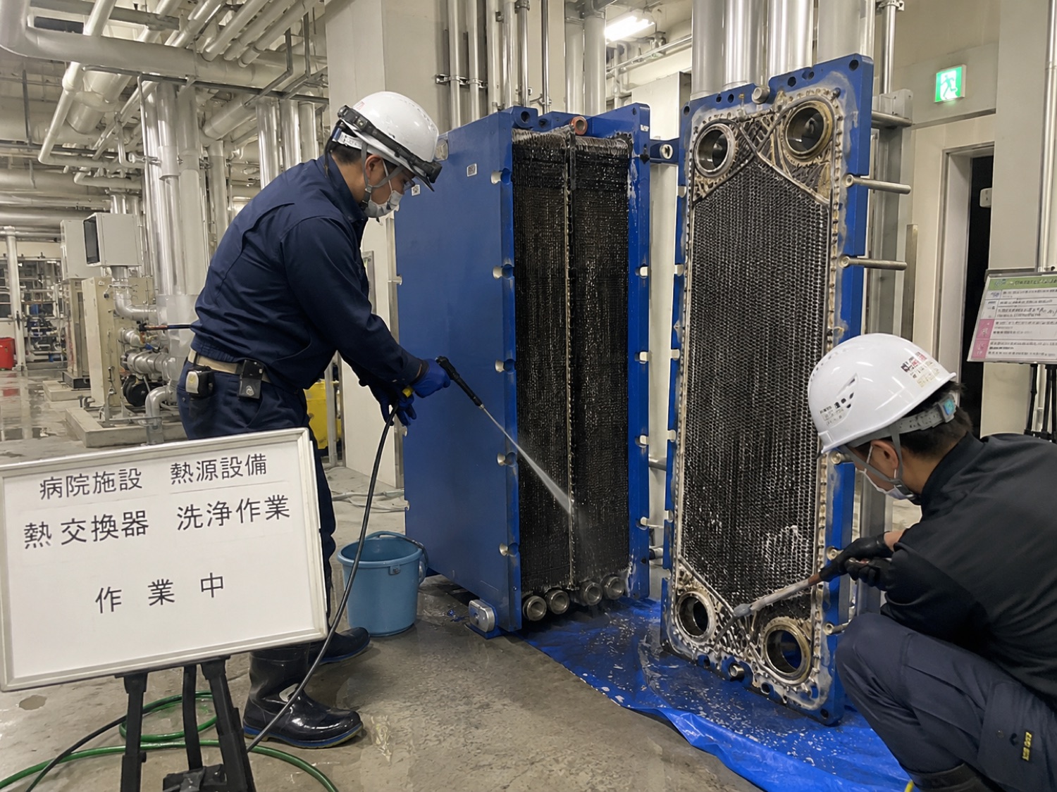 病院施設で熱交換器の洗浄作業にあたる技術者